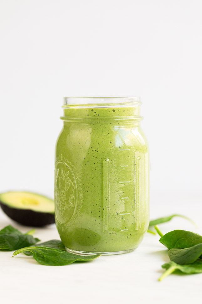 A side shot of a glass container with avocado smoothie