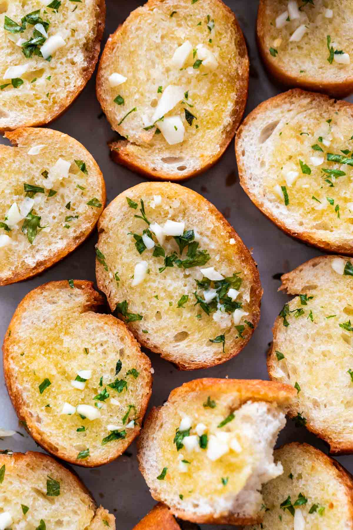Vegan garlic bread slices onto a white surface.