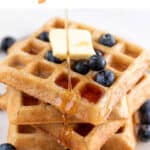 Vegan waffles with blueberries, vegan butter, and maple syrup drizzle.