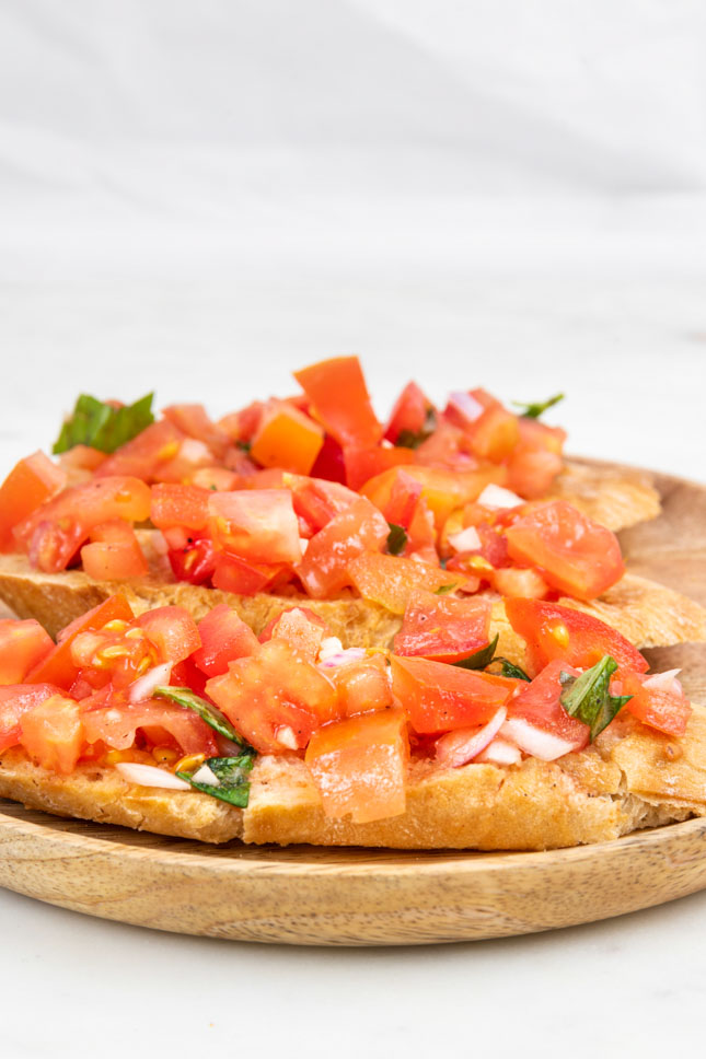 Photo of 3 bruschettas on a wooden plate
