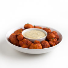 Square photo of a bowl of buffalo cauliflower wings