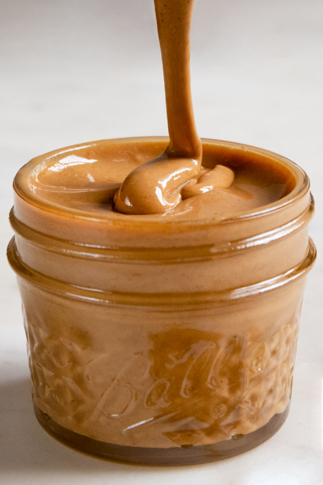 A clos shot of a jar with creamy homemade cashew butter