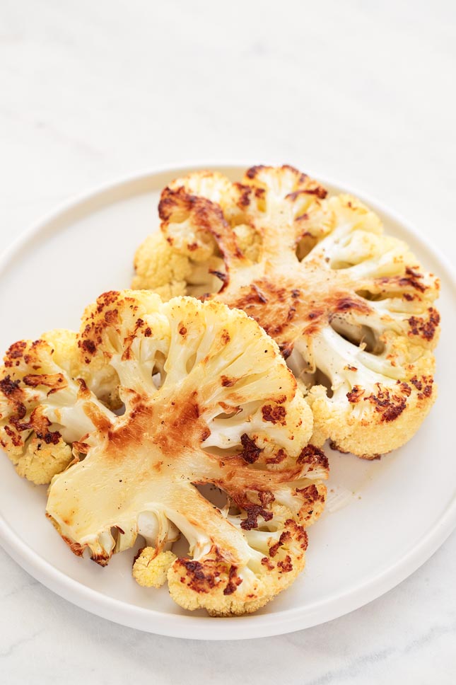 Close-up shot of 2 roasted cauliflower steaks