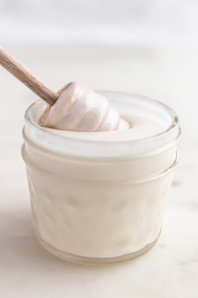 Photo of a little glass of coconut butter with a honey dipper in it