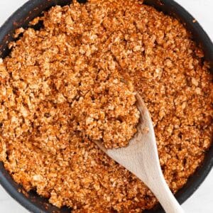 Overview of a frying pan with Chipotle sofritas and a wooden spoon.