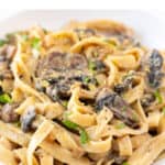 Plate of vegan mushroom pasta garnished with chopped cilantro.
