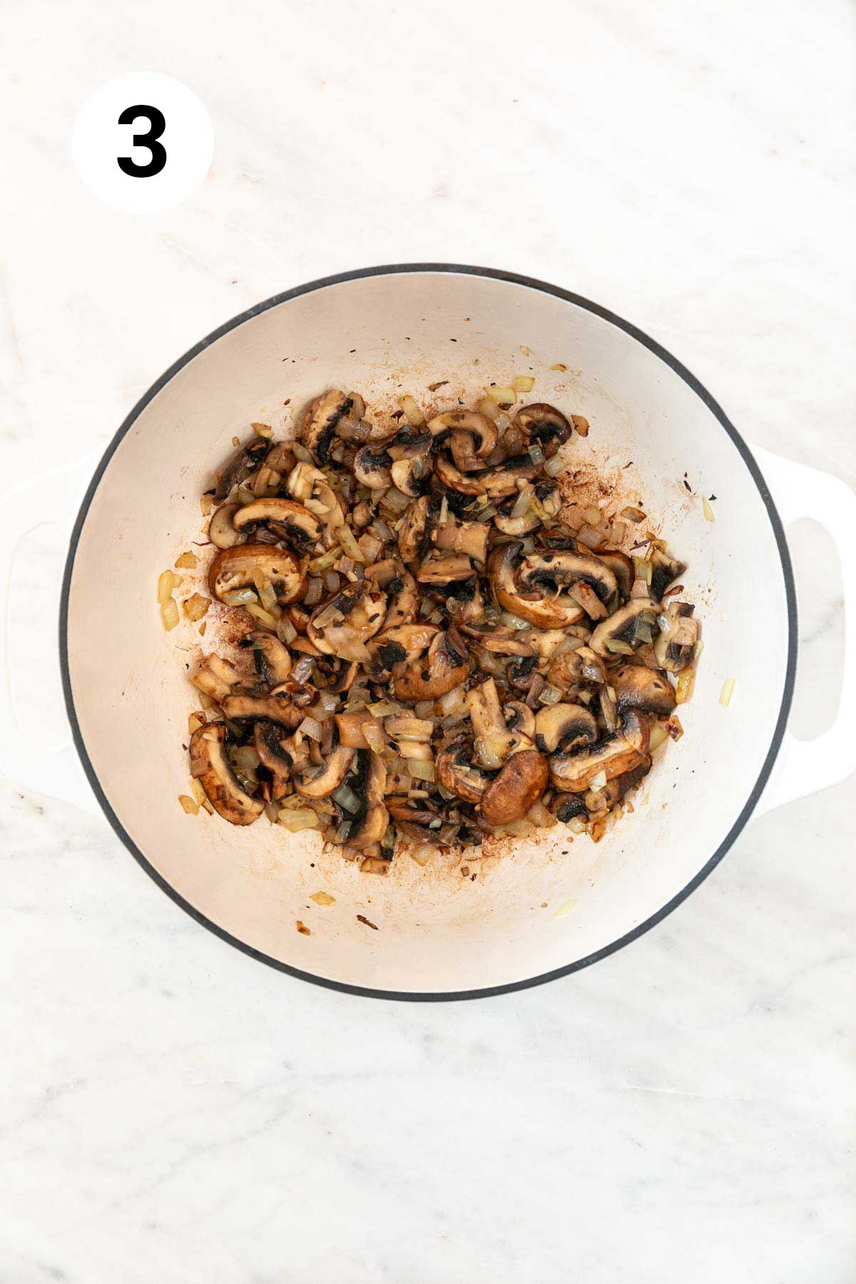 Sautéed onion, garlic, and mushrooms in a large pot.