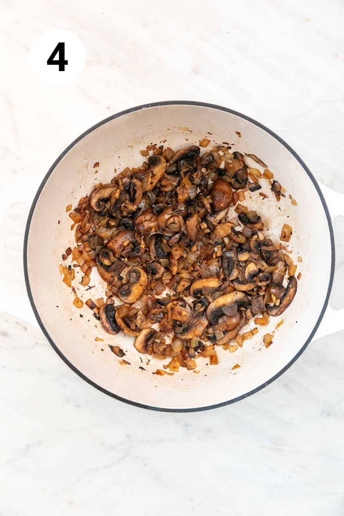 Sautéed onion, garlic, and mushrooms in a large pot after deglazing with wine.