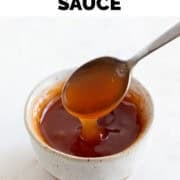 Spoon dipping into bowl of sweet and sour sauce.