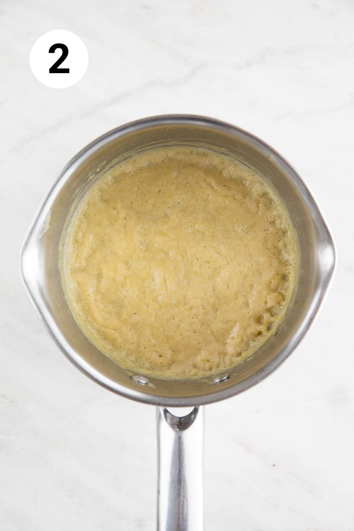 Saucepan with a cooked roux made with vegan butter and all-purpose flour.