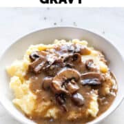 Vegan mushroom gravy over vegan mashed potatoes on a plate.