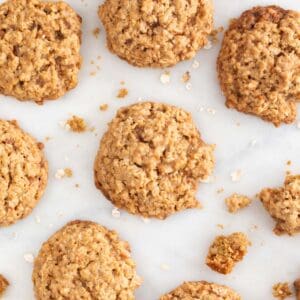 Lots of vegan oatmeal cookies on a marble slab.