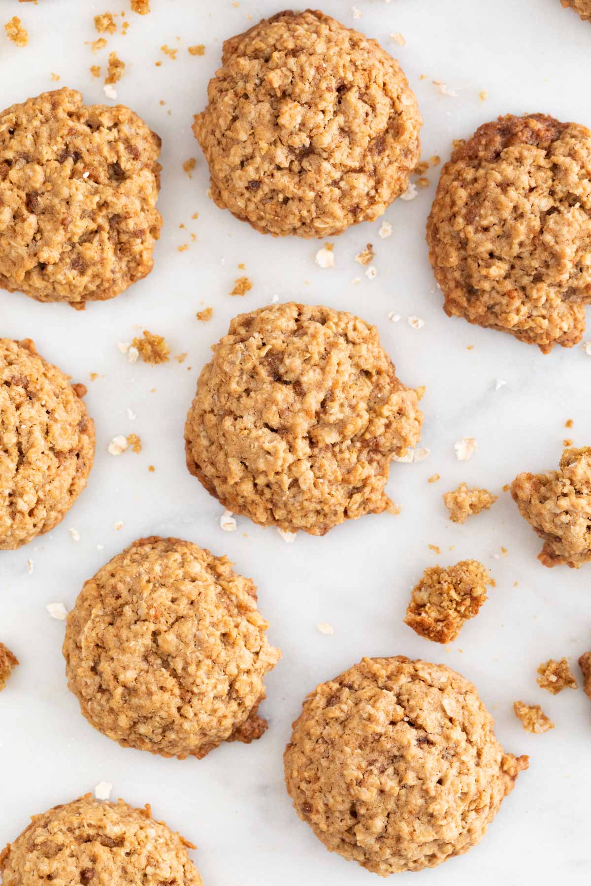 Lots of vegan oatmeal cookies on a marble slab.