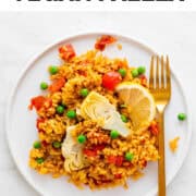 A dish of vegan paella with a golden fork.