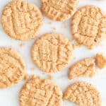 Lots of vegan peanut butter cookies on a marble slab.