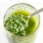 Jar with vegan pesto and a spoon.