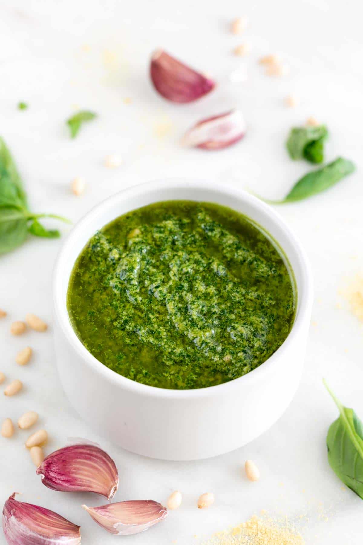 Vegan pesto bowl with ingredients in background.