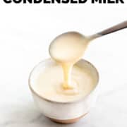 Spoon scoops vegan condensed milk from a bowl.