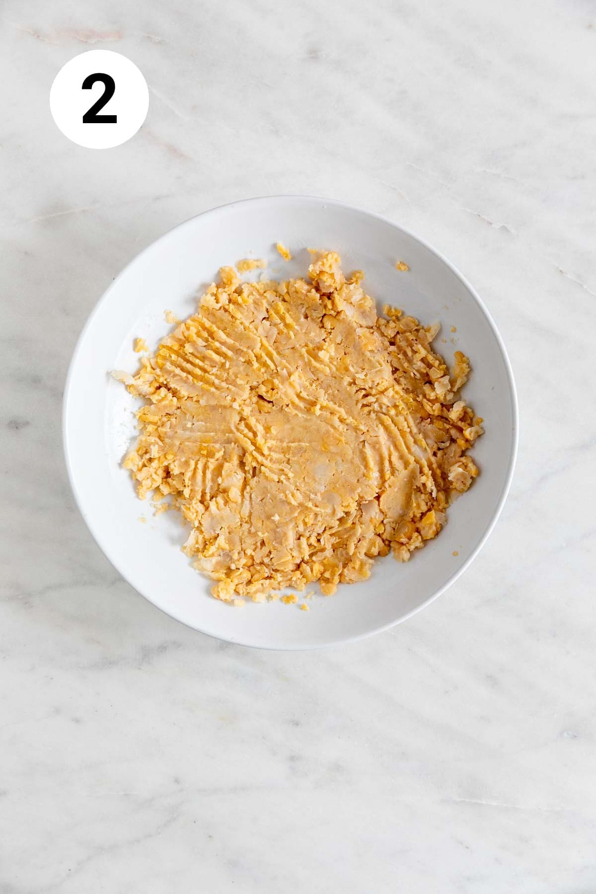 Mashed chickpeas in a shallow dish.