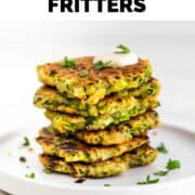 Vegan zucchini fritters served with a dollop of vegan sour cream and topped with parsley.