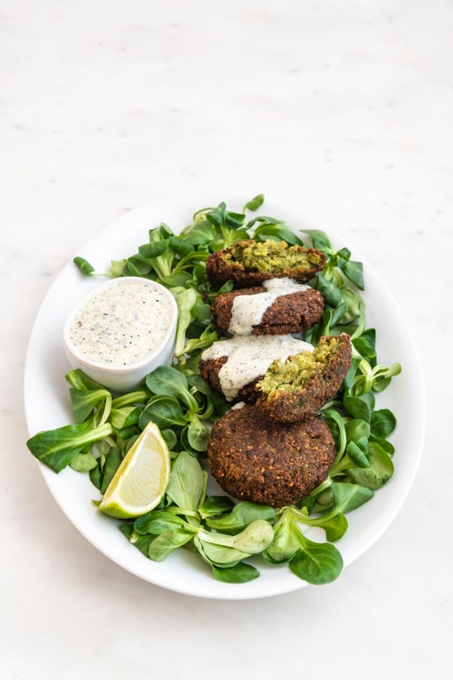 Photo of a plate of falafel, vegan yogurt sauce and some greens