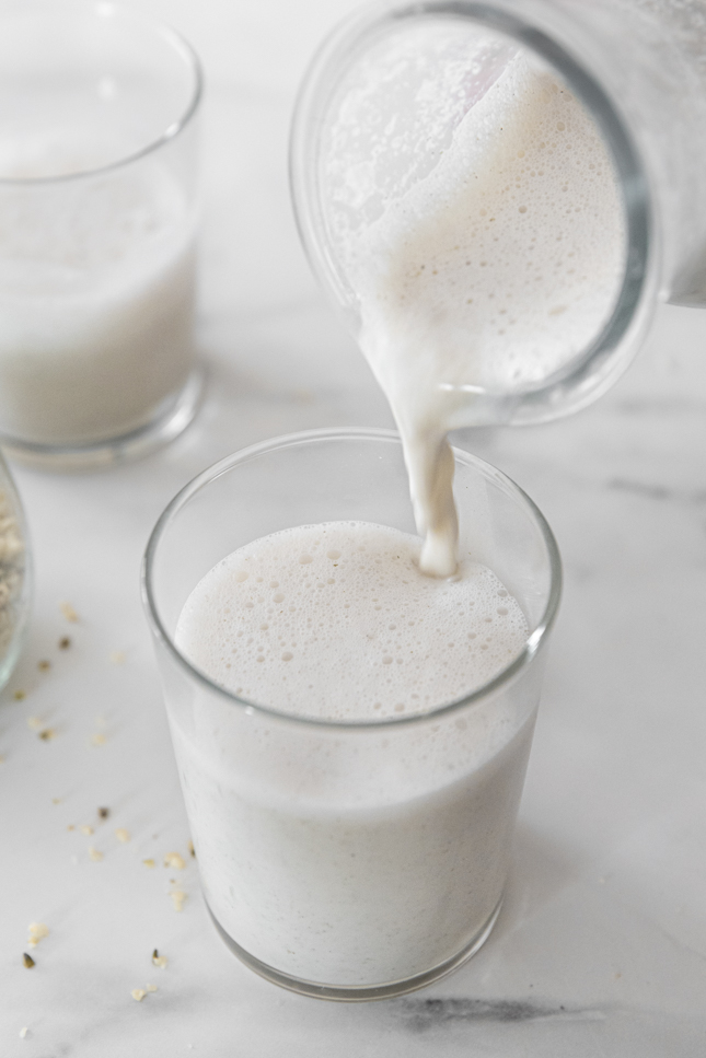 Photo of a bottle pouring hemp milk into a glass