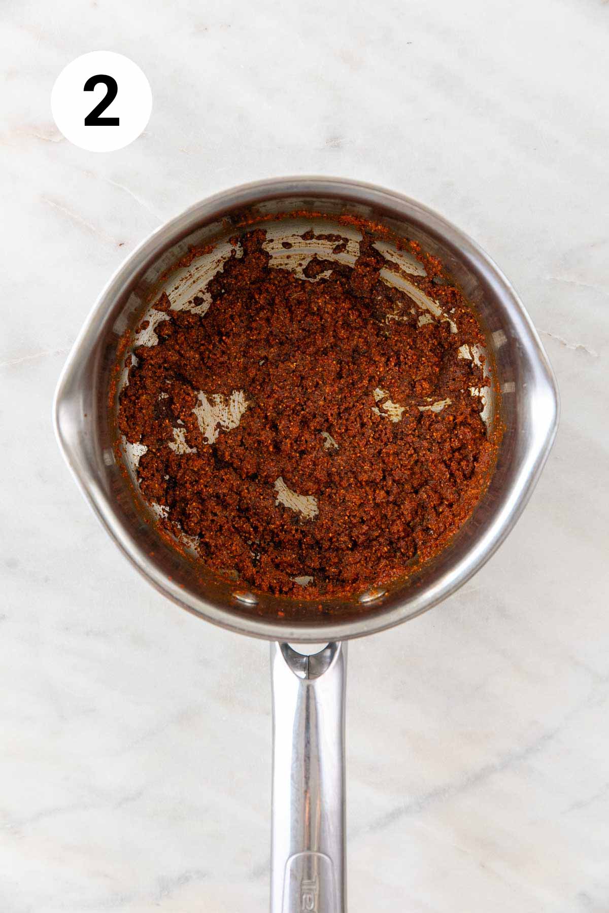 Flour mixture being sautéed in oil in a saucepan.