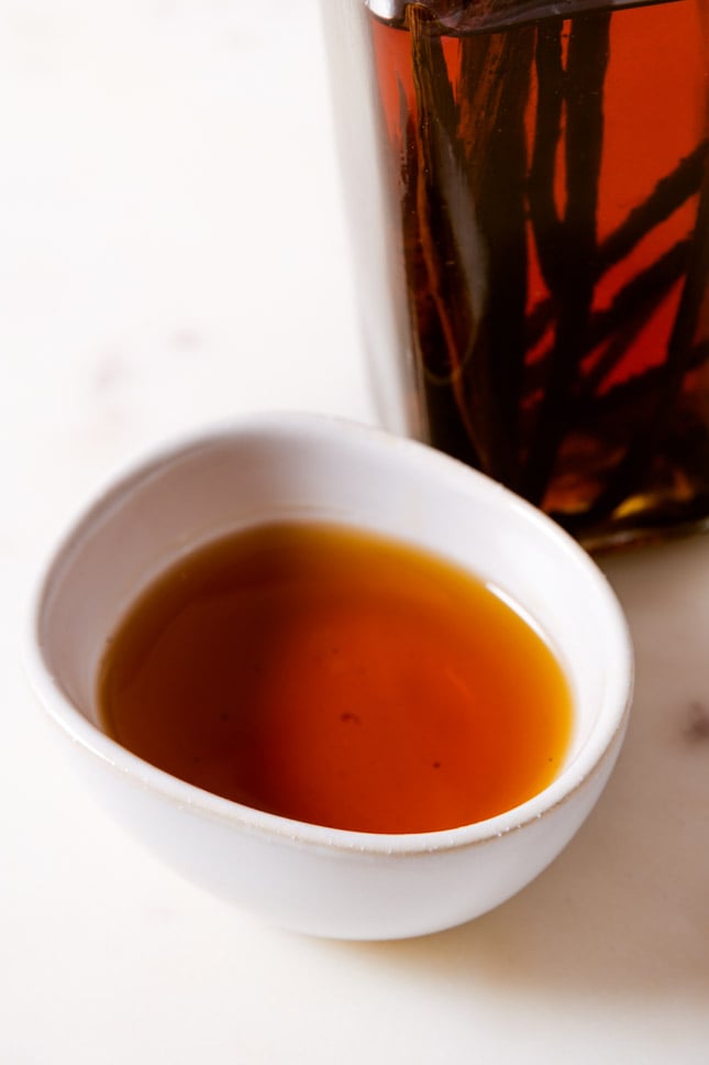 A picture of a bottle and a small bowl with homemade vanilla extract