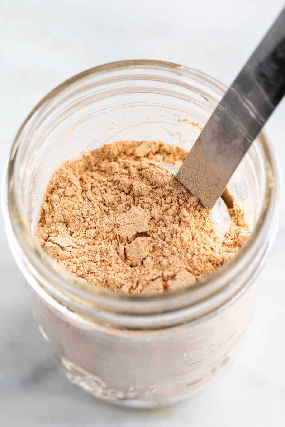 Vegan beef bouillon powder in a jar with a spoon.