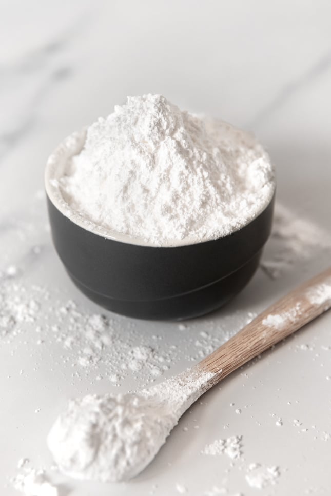 Photo of a bowl and a spoonful of powdered sugar