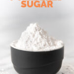 Side shot of a bowl of powdered sugar with the words how to make powdered sugar