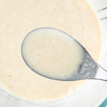 Measuring cup and spoon with vegan buttermilk.