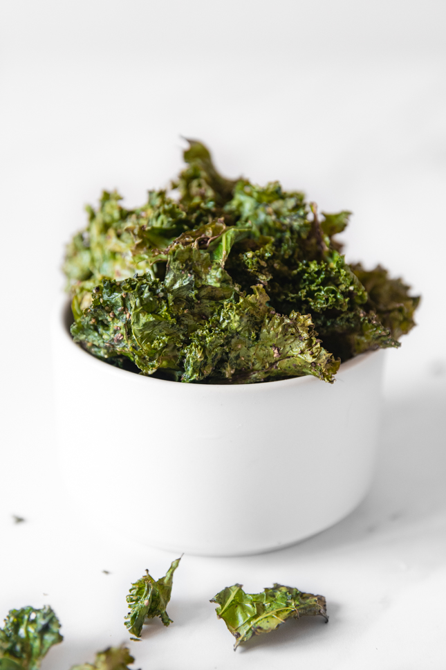 Side shot of a bowl of kale chips
