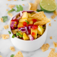 Square photo of a bowl of mango salsa