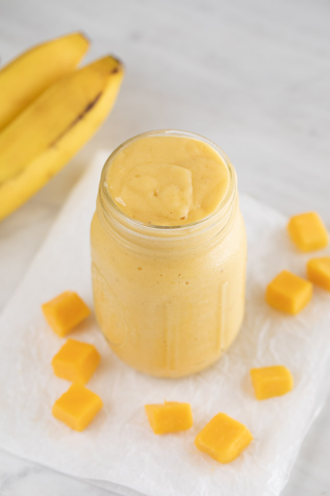 An overhead shot of a Mason jar with mango smoothie