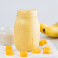 A small picture of a glass jar with mango smoothie