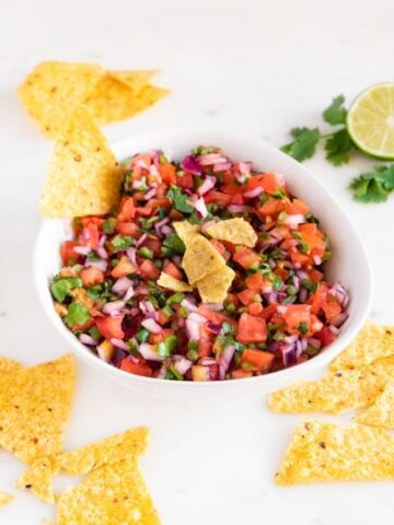Photo of a bowl of homemade pico de gallo with some tortilla chips
