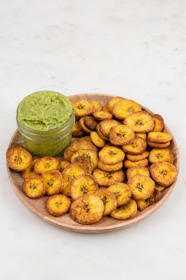Photo of a plate of plantain chips with a little bowl of guacamole