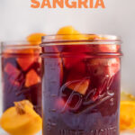 Side shot of a glass jar of sangria with the words how to make sangria
