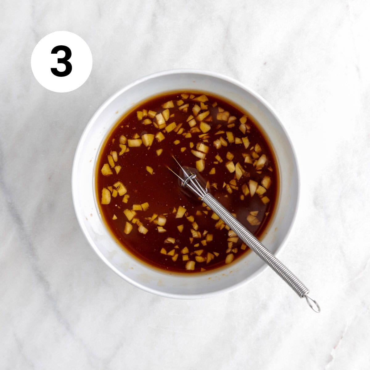 Sesame sauce in a bowl with a whisk after adding the slurry.