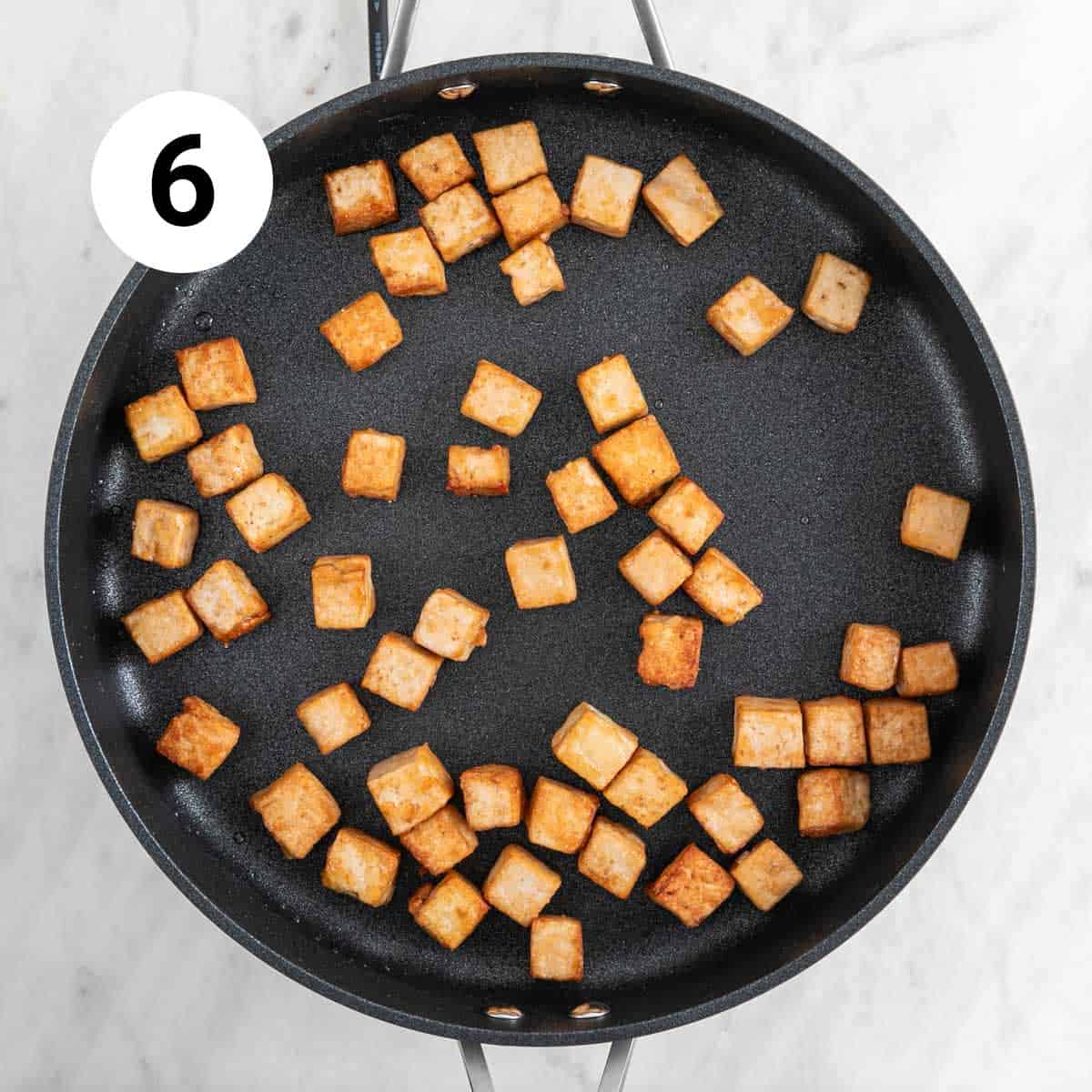 Sautéed tofu cubes in a skillet
