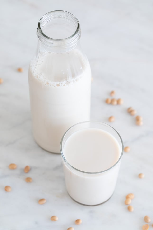 A picture of a bottle and a glass with soy milk made from scratch