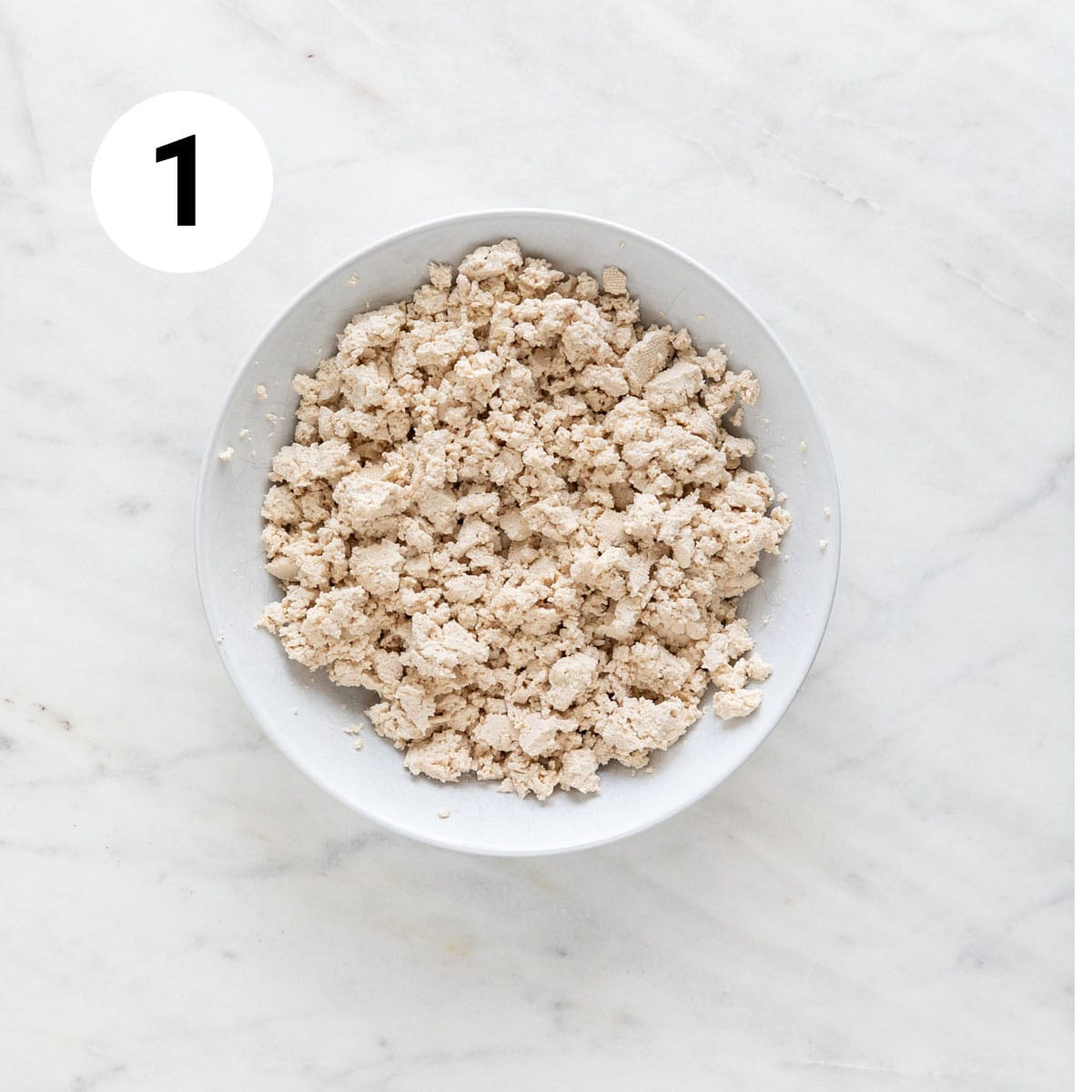 Tofu crumbles in a bowl.