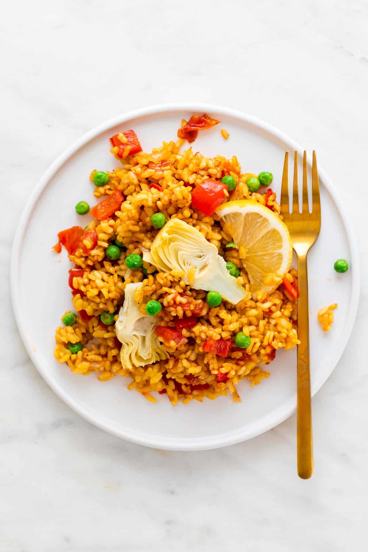 A dish of vegan paella with a golden fork.