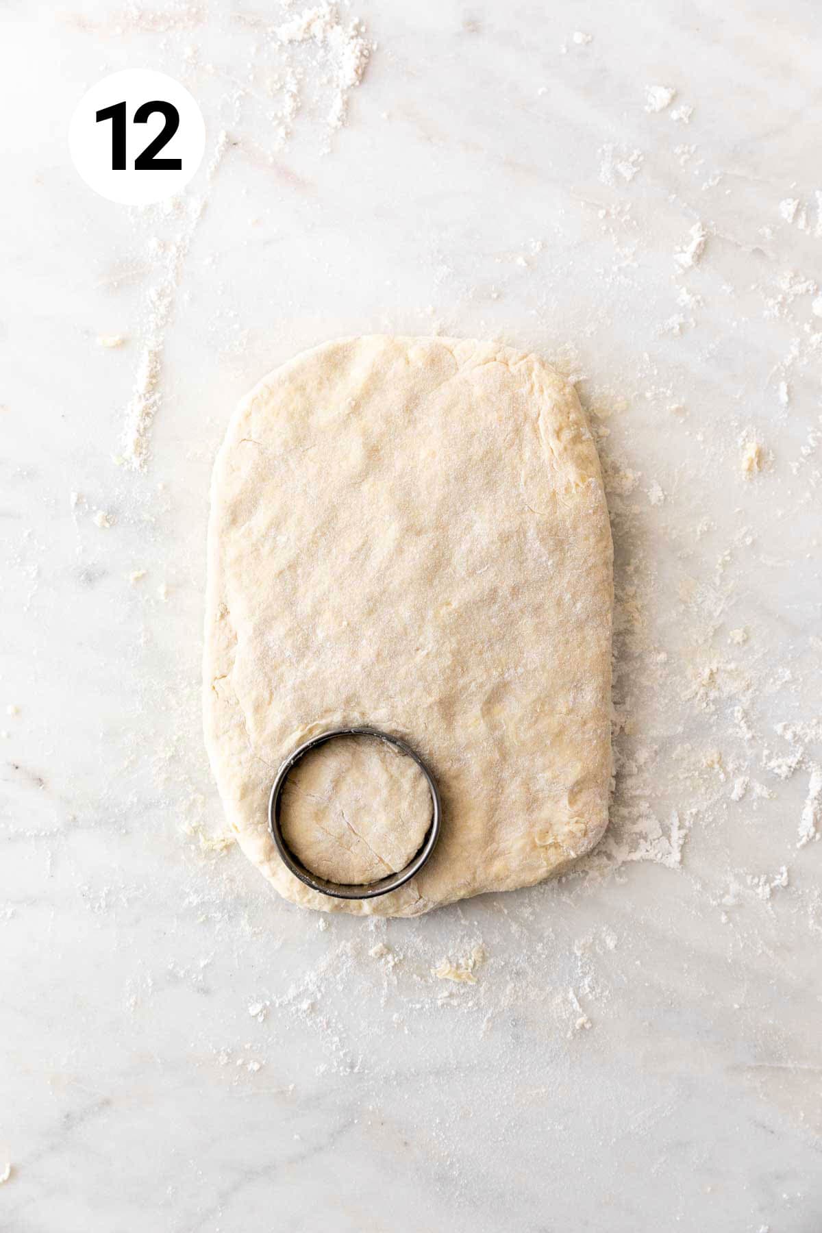 A biscuit cutter shaping the dough into biscuits.