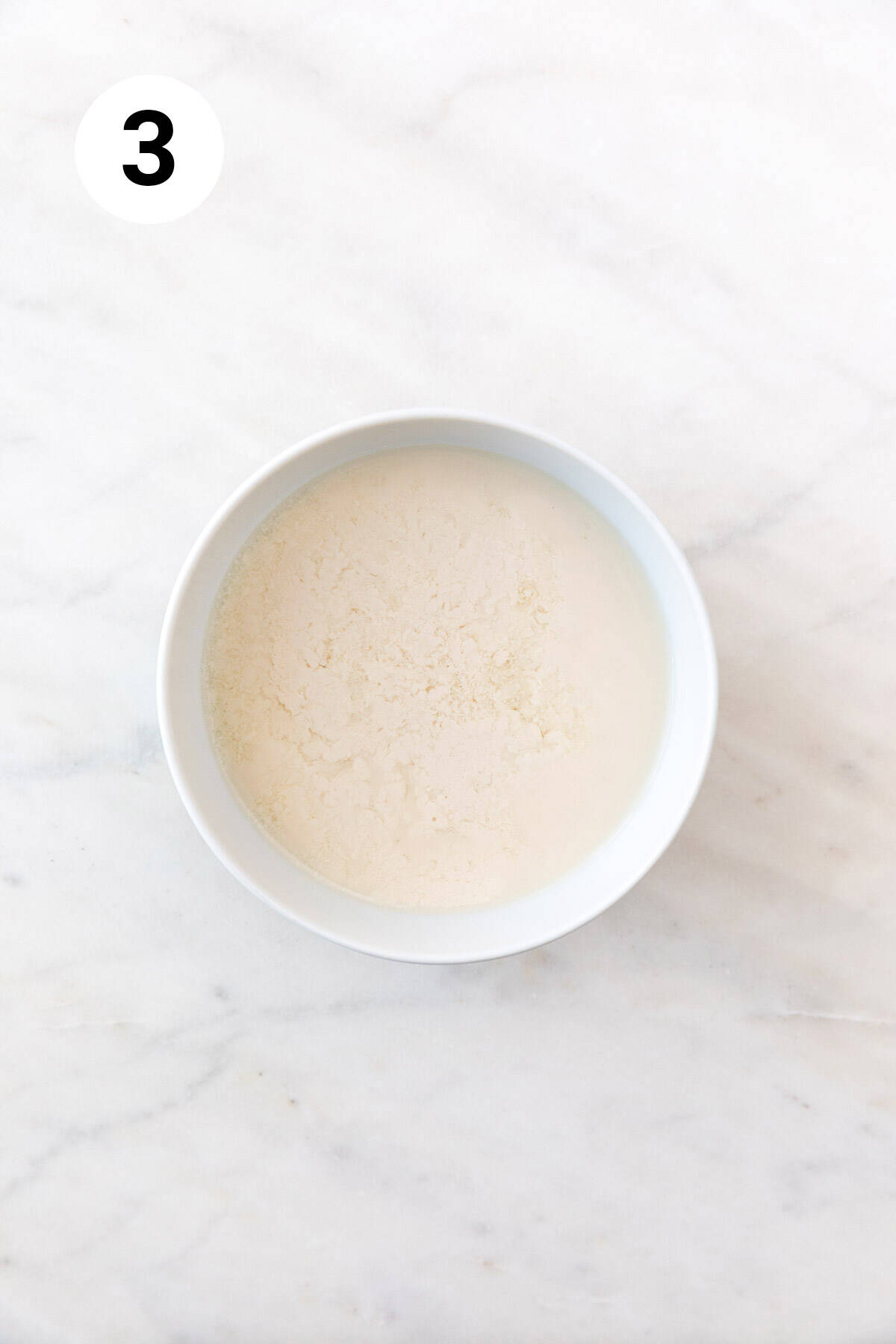 A bowl with non-dairy milk and vinegar mixture.