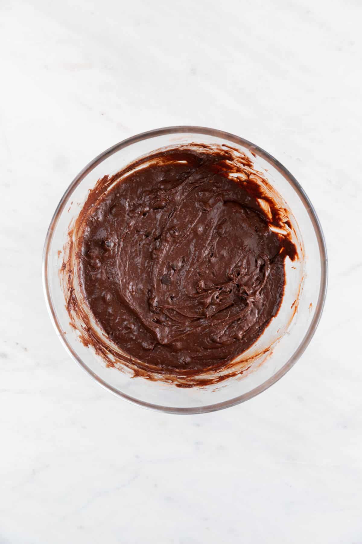 Vegan brownie batter with added chocolate chips in a large bowl.