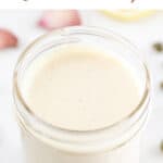 Vegan Caesar dressing in a mason jar surrounded by some ingredients.