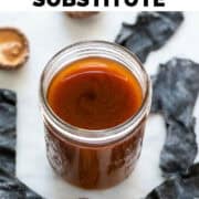 Vegan fish sauce in a jar with seaweed and dried mushrooms in the background.