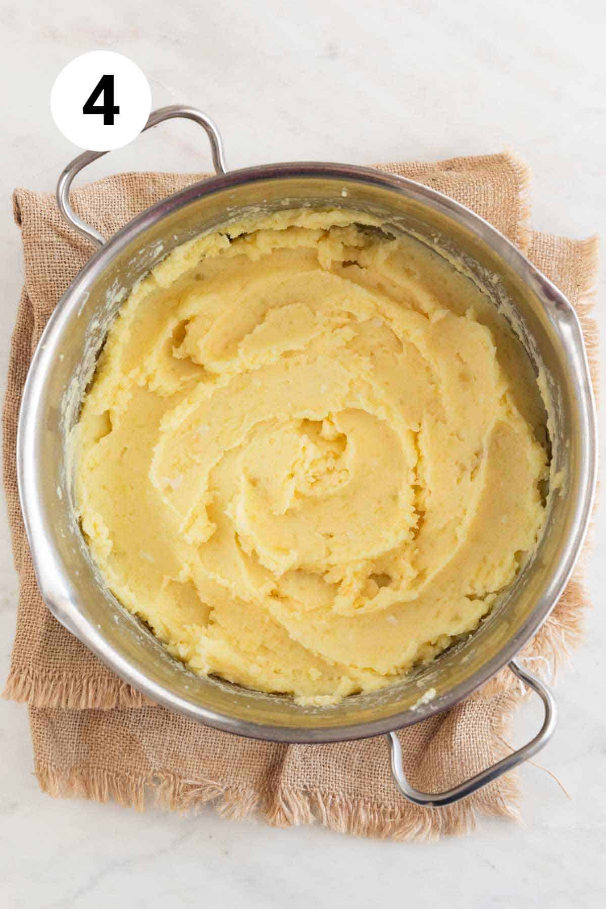 Large pot with vegan mashed potatoes after adding the milk.